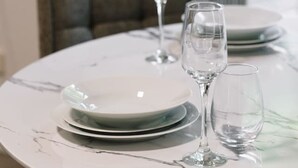 A dining table with plates and wine glasses, a chair, and a window in the background. - Peaceful Retreat Near Shops & Cafés|Secure Parking (Mount Warren Park)