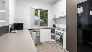 A modern kitchen with white cabinets, a dishwasher, an oven, and a refrigerator. - Peaceful Retreat Near Shops & Cafés|Secure Parking (Mount Warren Park)