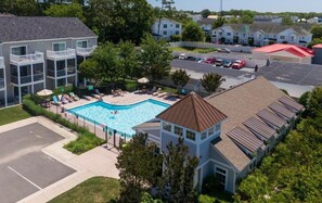 A residential building with a swimming pool, multiple balconies, and a parking area. - Rehoboth 4BR Townhome Sleeps 10 Bike to Beach (Rehoboth Beach)