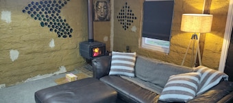 Mudbrick self contained studio with wood heater