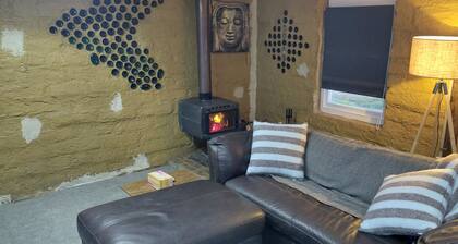 Mudbrick self contained studio with wood heater