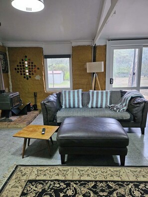Living area - Mudbrick self contained studio with wood heater (Mandurang South)