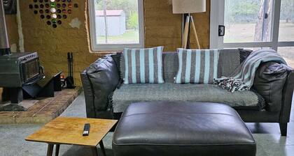 Mudbrick self contained studio with wood heater