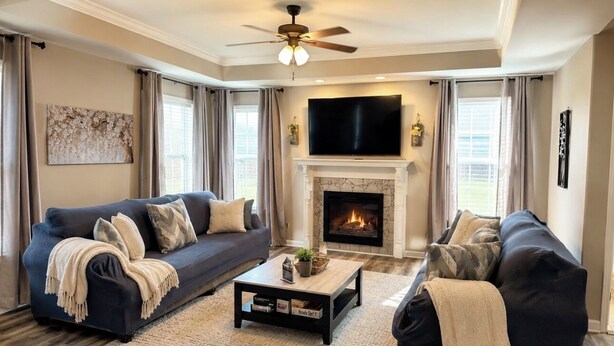 A living room with two dark sofas, a coffee table, a fireplace, and a TV mounted above it. - Spacious Family Home• Sleeps 8 • Near Ft Campbell (Clarksville)