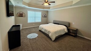 A bedroom with a bed, ceiling fan, window, and a small table. - Spacious Family Home• Sleeps 8 • Near Ft Campbell (Clarksville)