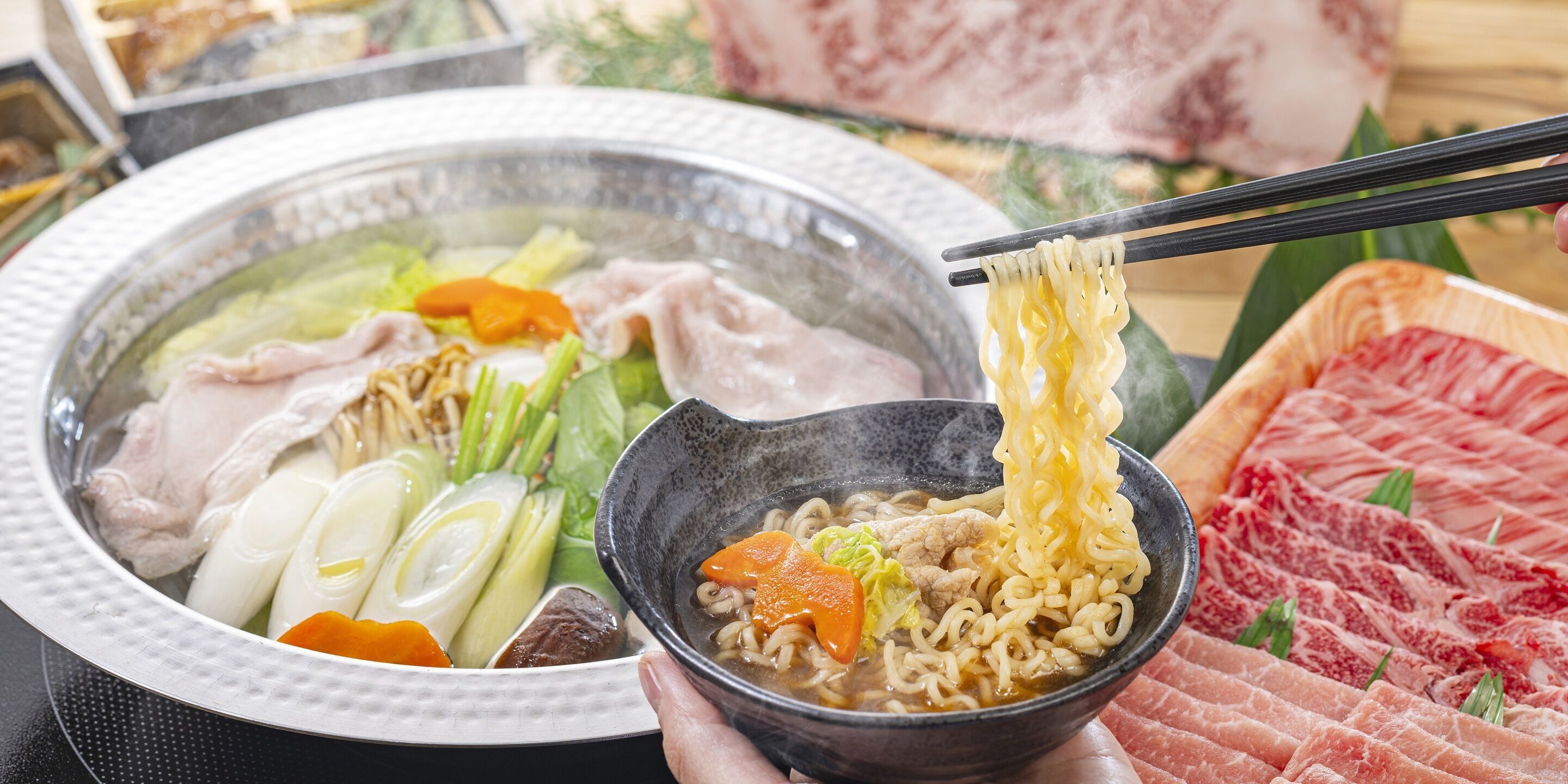 Un tazón de ramen con diversos ingredientes, un plato de carne cruda y un bol de sopa con verduras.