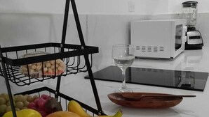 A kitchen with a fruit basket, a microwave, and a wine glass. - Luxury apartment close to the sea north of Cartagena (Cartagena de Indias)
