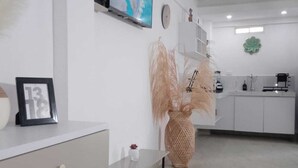 A modern kitchen with white cabinets, a built-in oven, and a small island with a sink. - Luxury apartment close to the sea north of Cartagena (Cartagena de Indias)