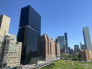 A cityscape with modern high-rise buildings, a mix of architectural styles, and a clear blue sky. - 2 Bedroom 2 Bath Luxury 3m NYC Apartment with River Views, Doorman, Gym, Pool (New York)