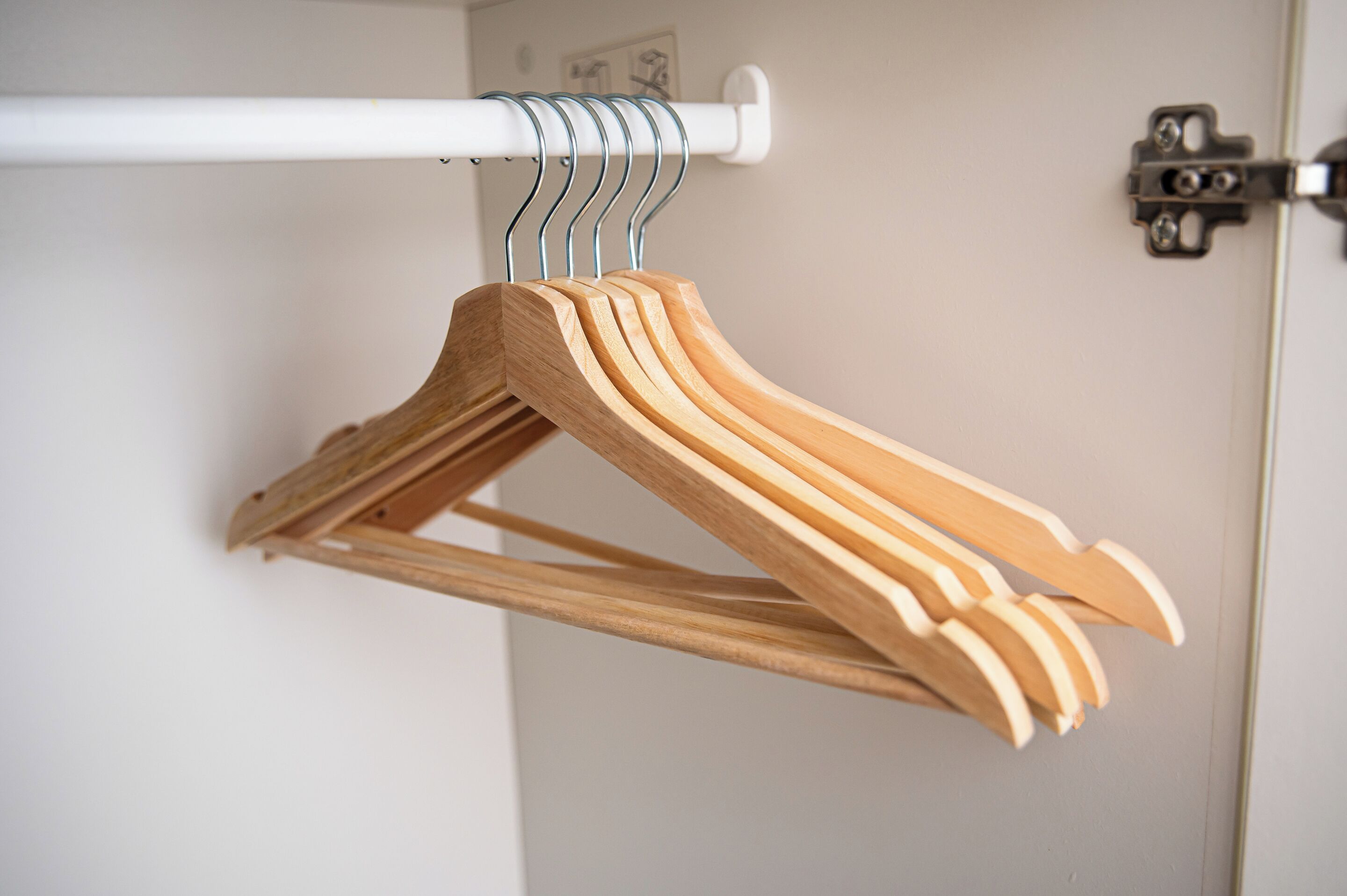 Cabides de madeira em um varão de metal branco.
