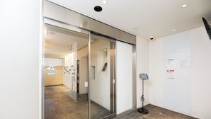 A modern interior with a glass door, a digital information kiosk, and a clean, minimalist design. - Uni Brilliart Hakata (Fukuoka City)