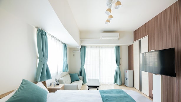 A hotel room with a bed, a desk, a chair, a TV, and a window with curtains. - Uni Brilliart Hakata (Fukuoka City)