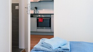 Quarto com cama, banheiro com chuveiro e cozinha com forno.