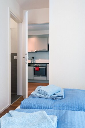 Ein Schlafzimmer mit Bett, ein Badezimmer mit Dusche und eine Küche mit Backofen.