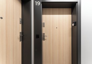 A hotel room with a wooden door, a black door frame, and a number '19' on the door.