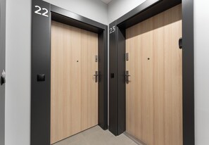 A set of double doors with numbers 22 and 23, indicating a hotel room or office space. - Rondo Matecznego Studio #23 (Kraków)