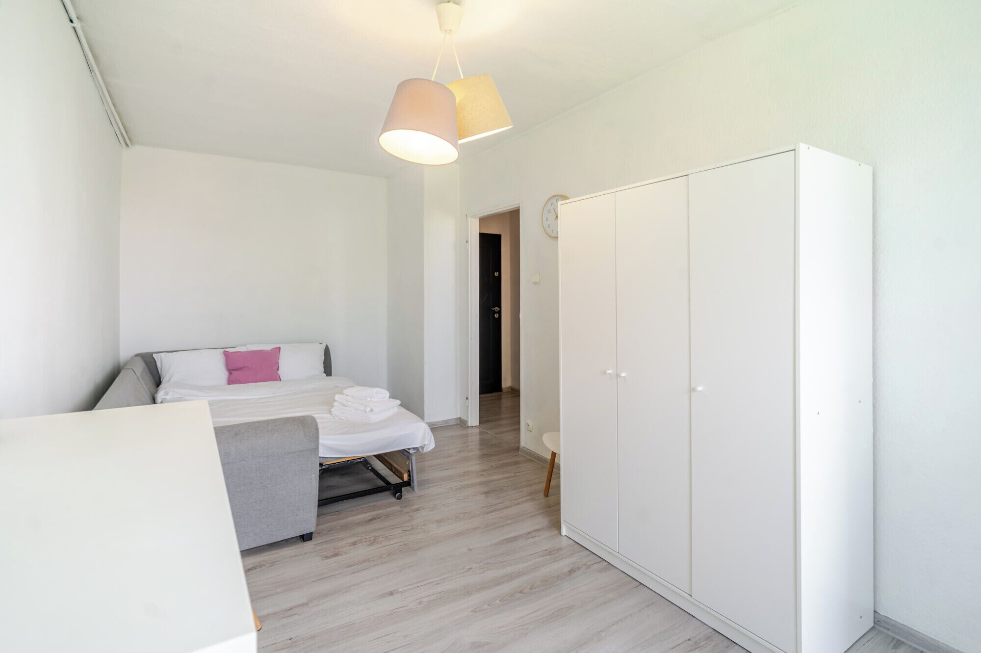 Ein Schlafzimmer mit einem Bett, einem Kleiderschrank und einer Pendelleuchte.