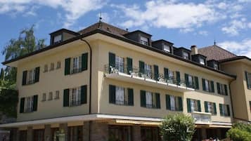 Un immeuble à plusieurs étages, doté de balcons, d’une façade en pierre et d’un toit plat.