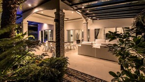 A modern interior with a reception desk, glass doors, and a ceiling with exposed beams. - Orchid Paradise Homes OPV03 (Hin Lek Fai)