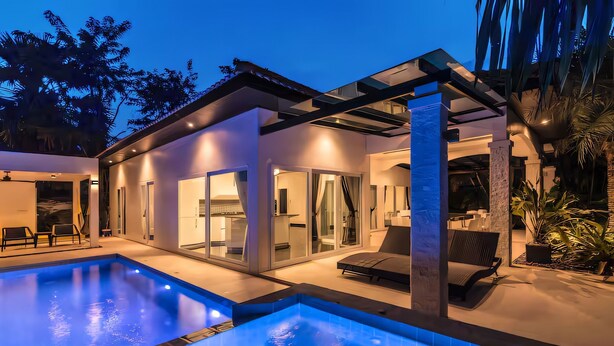 A modern house with a swimming pool, glass doors, and outdoor seating. - Orchid Paradise Homes OPV03 (Hin Lek Fai)