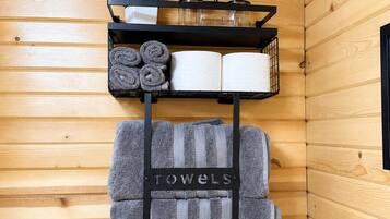 A wooden interior with a towel rack labeled 'TOWELS' holding multiple towels.