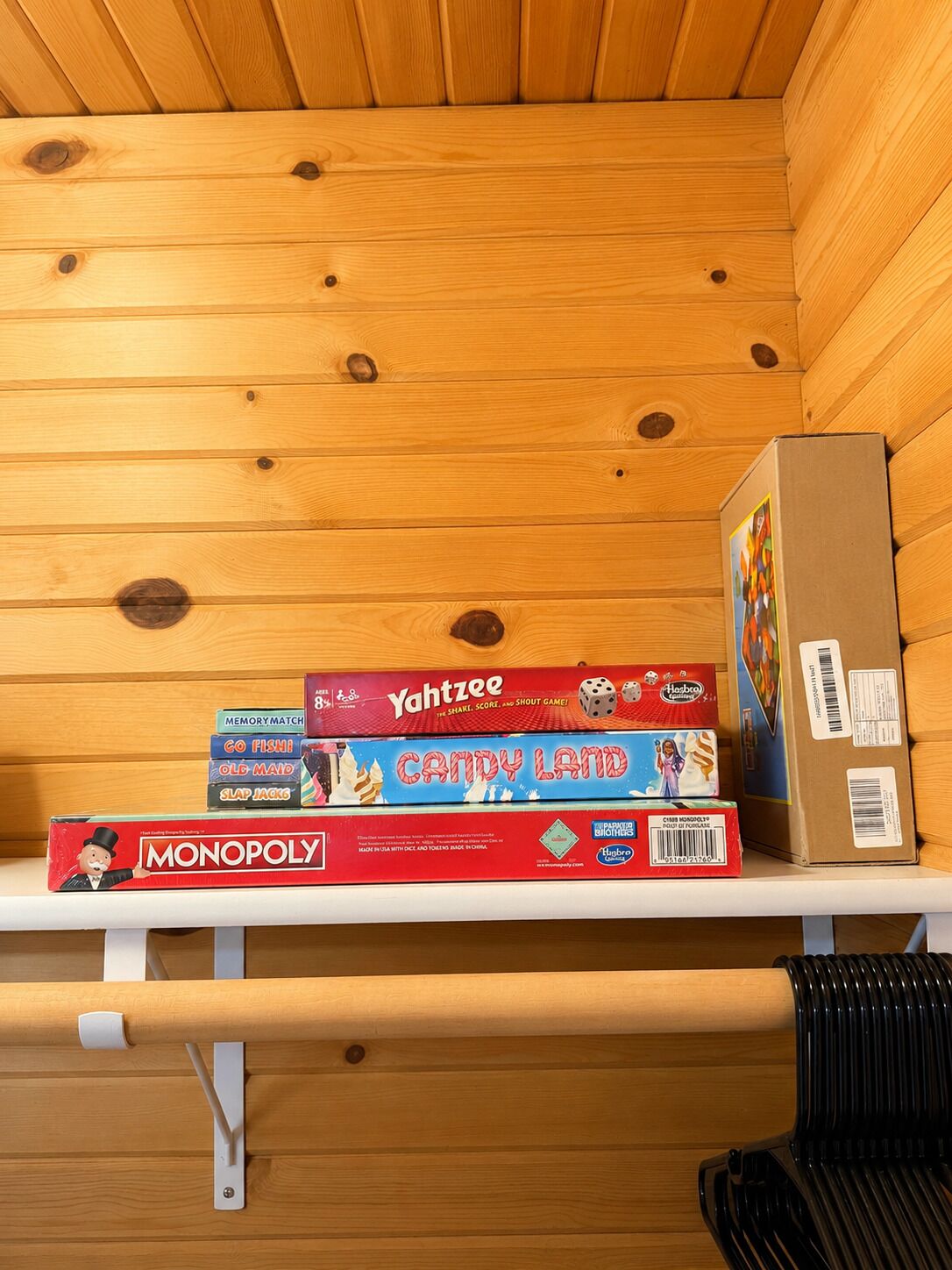 A shelf with board games and a cardboard box.