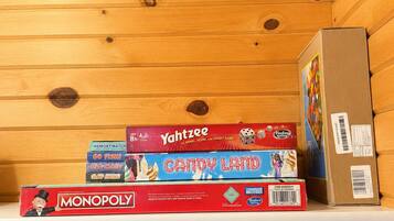 A shelf with board games and a cardboard box.