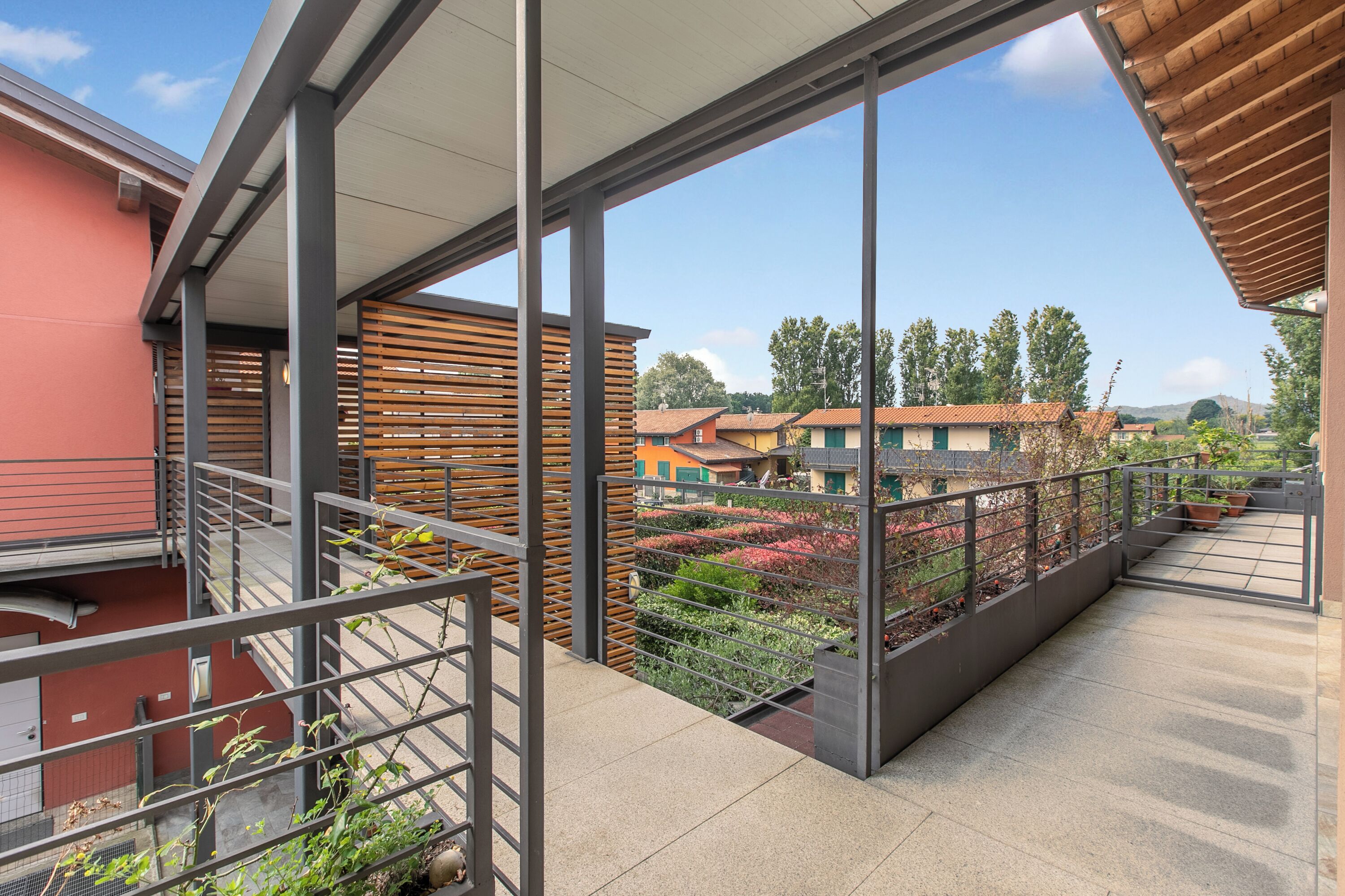 A balcony with a view of neighboring houses and trees.