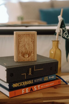 A stack of books with a carved wooden block on top.
