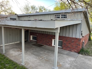A covered patio area with a brick wall and a metal roof.