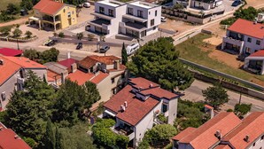 Vista aérea de una zona residencial con casas modernas, una carretera y follaje circundante.