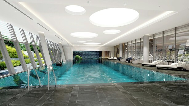 En inomhuspool med modern design, omgiven av avslappningsområden och en vägg av glas.