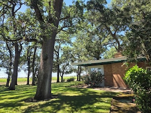 A house with a brick exterior, a green roof, and a small porch.