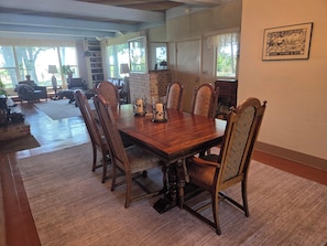 A dining area with a wooden table, chairs, and a fireplace.