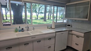 A kitchen with a large window, a sink, and a dishwasher.