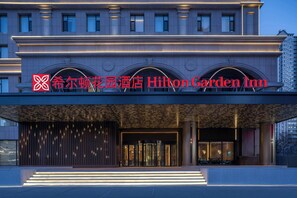 A modern hotel entrance with a prominent sign, a covered entrance, and a well-lit facade. - Hilton Garden Inn Harbin Haxi (Harbin)