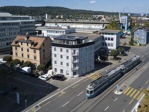 Eine moderne Stadtstraße mit Straßenbahnschienen, Gebäuden und freiem Blick auf die Umgebung.