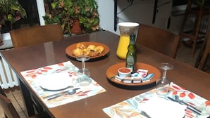 A dining table with placemats, plates, cutlery, and a bottle of juice. - Hotel Alto de las Estazadas (Cabrales)