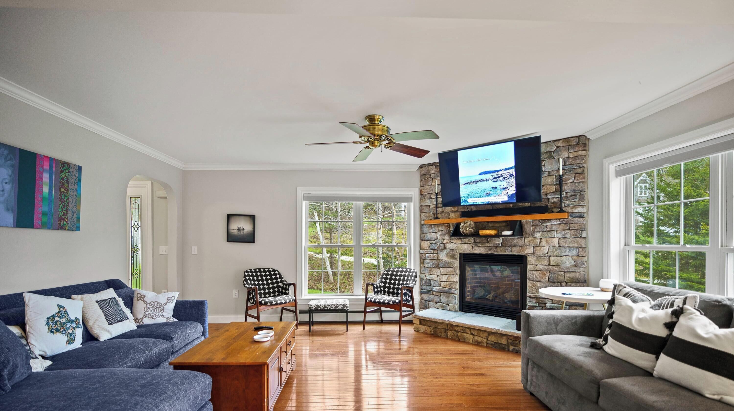 En stue med en stenspir, et fjernsyn og to sofaer.