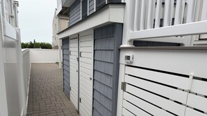 A narrow pathway leading to a building with a gated entrance and a security camera. -  4 bedroom + bonus room house  with ocean view in Sea Isle City (Sea Isle City)
