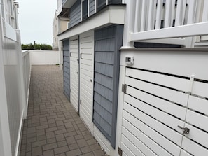 En smal gång som leder till en byggnad med en grind vid ingången och en övervakningskamera.