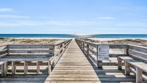 A wooden boardwalk leading to a beach with a warning sign. - Beach View Plantation 4515 With Multiple Resort Amenities (Gulf Shores)