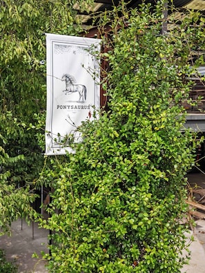 A sign with a horse illustration and the text 'PONYSAUERUS' partially obscured by foliage. - 7 Min Walk to Golden Belt | 8 Min to Hospital (Durham)