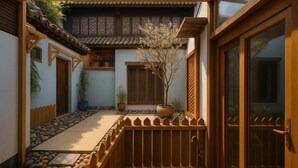 A traditional Japanese-style courtyard with a wooden fence, potted plants, and a tiled roof. - Cloud and Wind (Yangzhou)