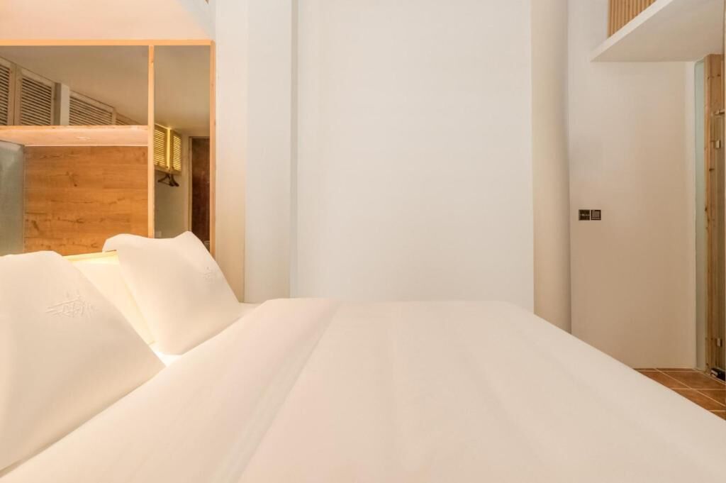Ein Schlafzimmer mit einem Bett, Holzwandverkleidung und einer Tür.