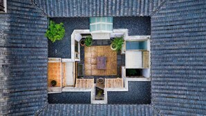 An aerial view of a courtyard with a wooden deck, seating area, and potted plants. - Cloud and Wind (Yangzhou)