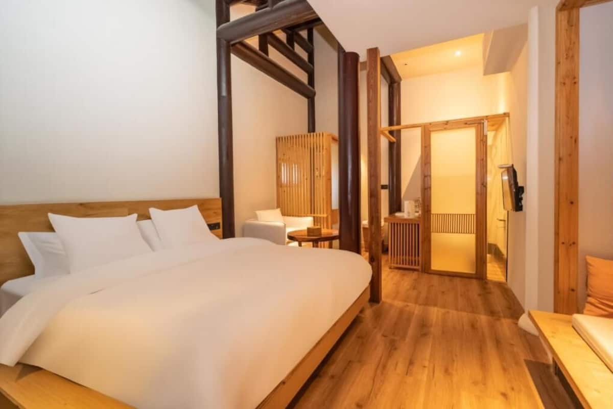 A bedroom with a wooden bed, a small table, and a chair.