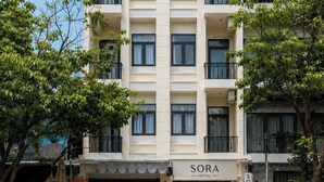 A multi-story hotel with a flat facade, balconies, and a sign reading 'SORA HOTEL'. - SORA HOTEL & APARTMENT (Ho Chi Minh City)