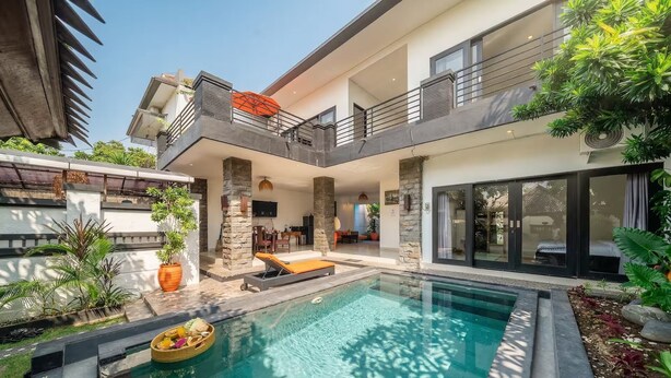 A modern house with a swimming pool, outdoor seating, and a balcony. - Sunbeji Villa (Seminyak)