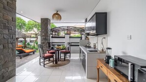 A modern kitchen with a built-in oven, a microwave, and a coffee maker. - Sunbeji Villa (Seminyak)